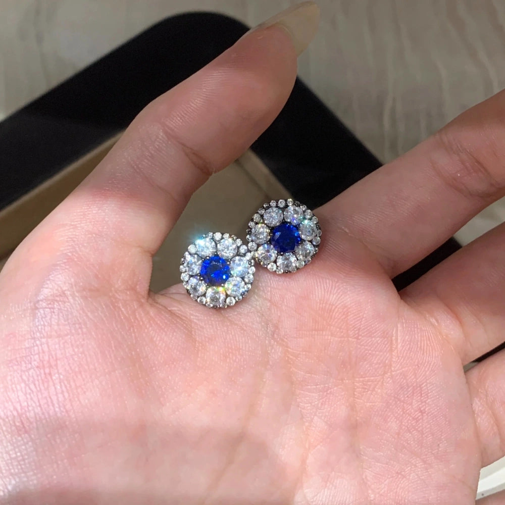 Woman wearing 5mm royal blue lab-grown diamond halo stud earrings, showcasing the 1.5cm vintage design