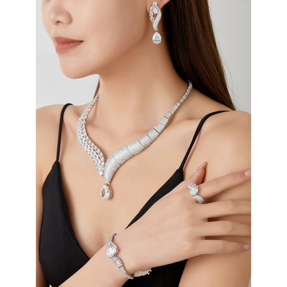 Crystal clear cubic zirconia jewelry set with silver-tone finish. Includes necklace, ring, earrings, and bracelet for weddings and formal wear