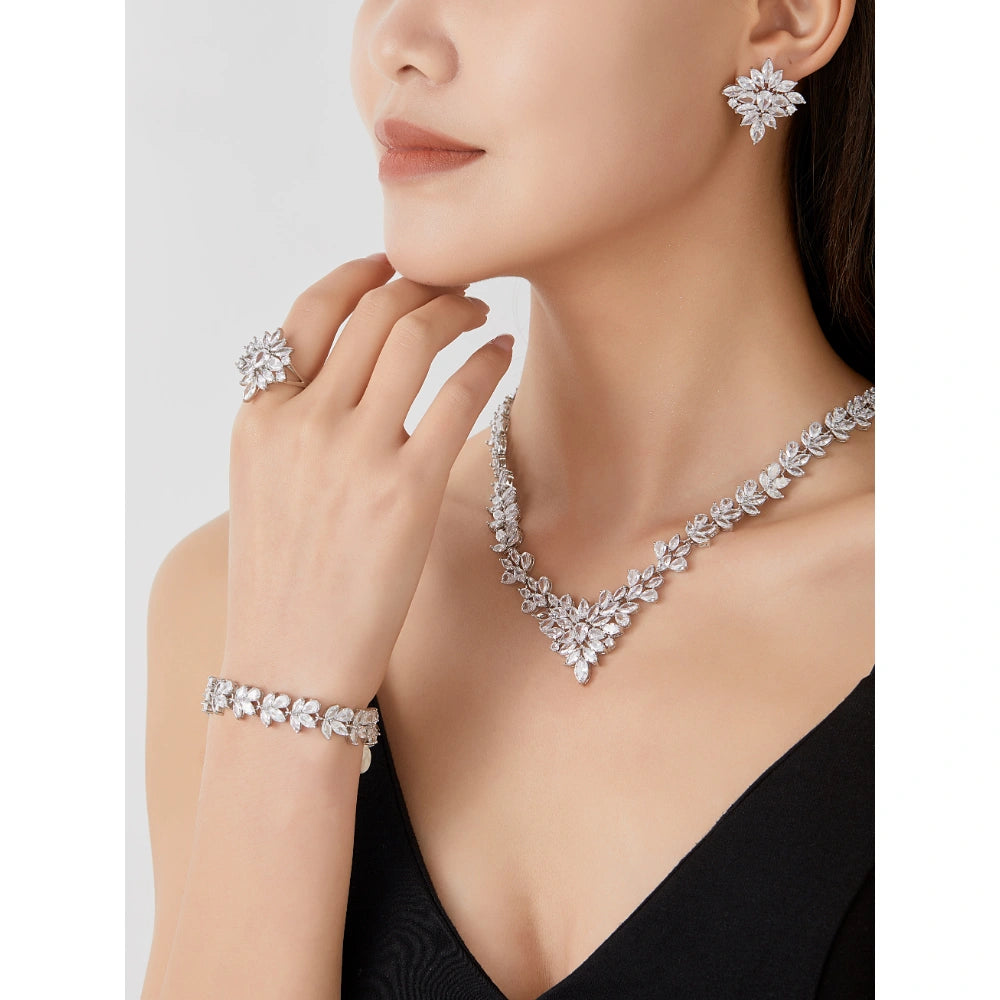 Crystal clear zircon jewelry set with silver-tone finish. Includes necklace, ring, earrings, and bracelet for weddings and formal wear