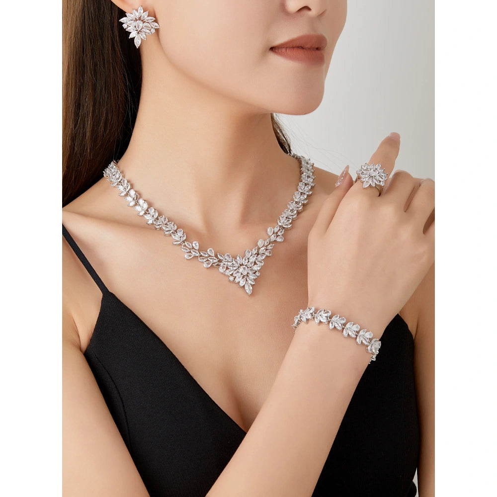 Crystal clear zircon jewelry set with silver-tone finish. Includes necklace, ring, earrings, and bracelet for weddings and formal wear