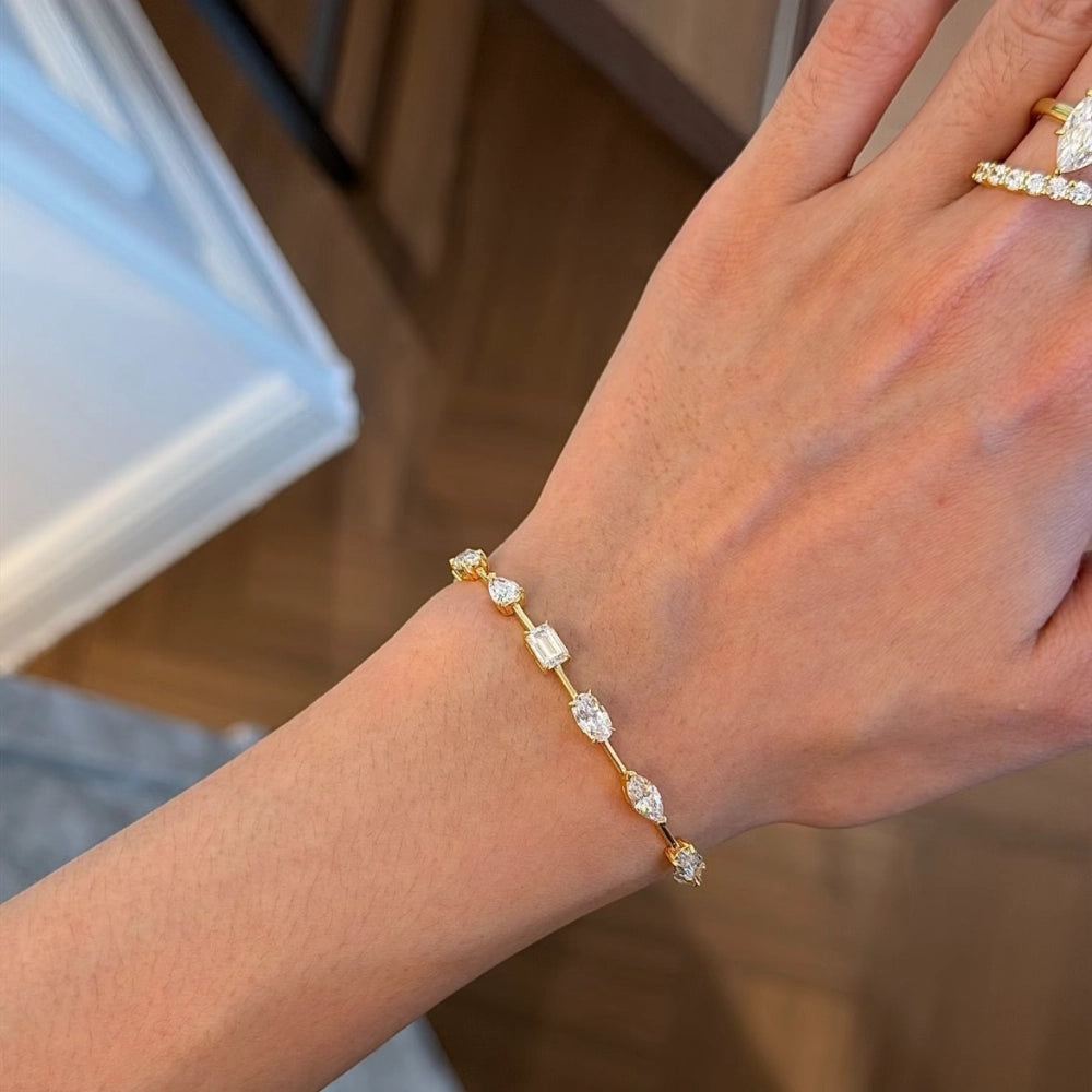 Flat lay of lab-grown diamond fancy cut bracelet showing marquise, pear, oval and mixed cut stones in gold-plated silver