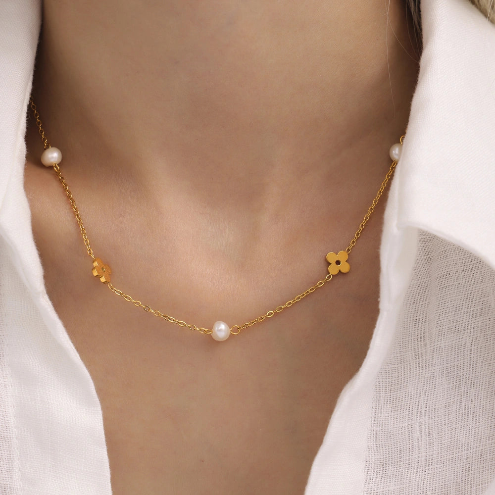 Close-up of the delicate gold flower chain and a lustrous freshwater pearl on the necklace