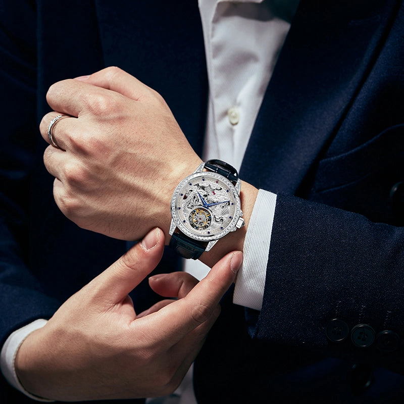 Luminous blue watch hands glowing in low light on silver dragon skeleton dial