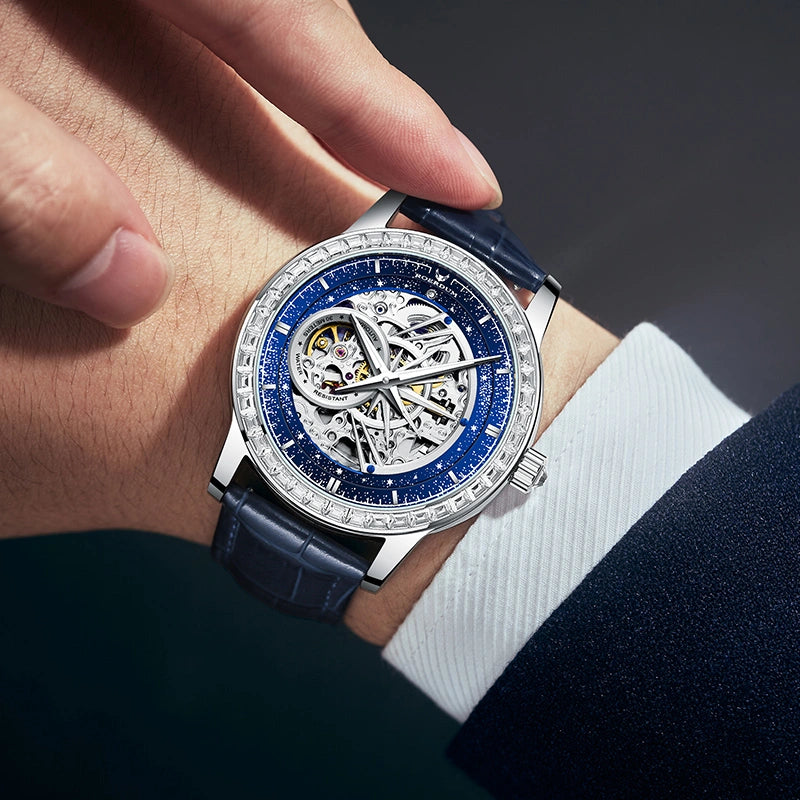 Close-up of man wearing 42mm blue celestial automatic watch on wrist with a navy suit