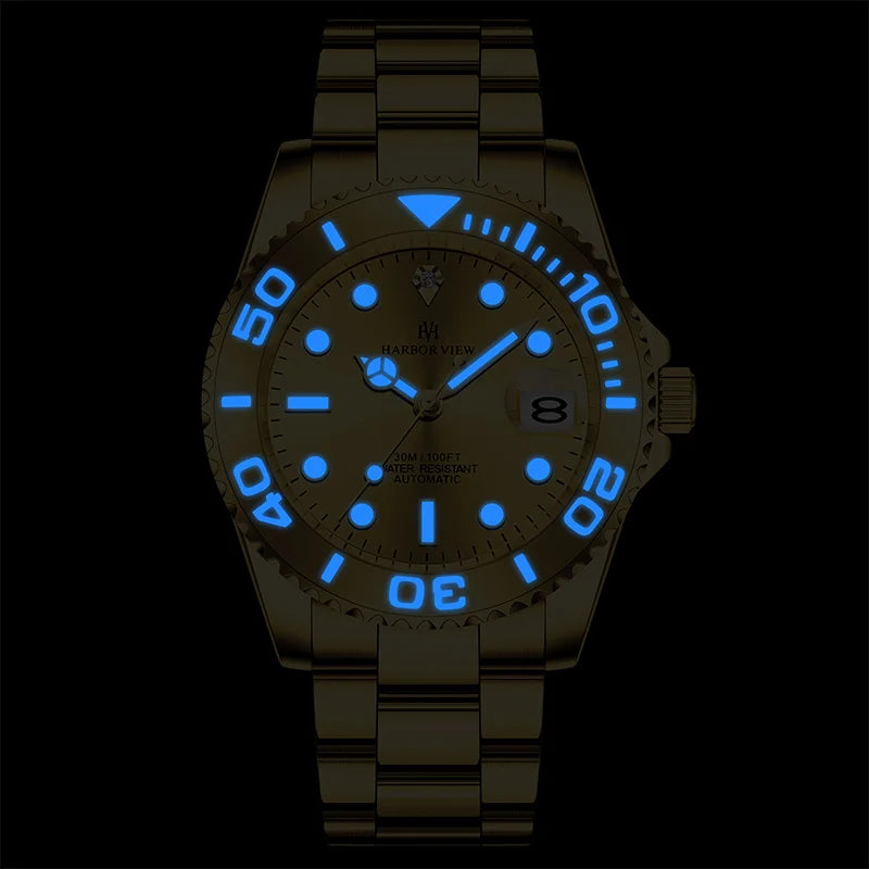 Glowing blue luminous hands and hour markers of the gold yacht style automatic watch in the dark