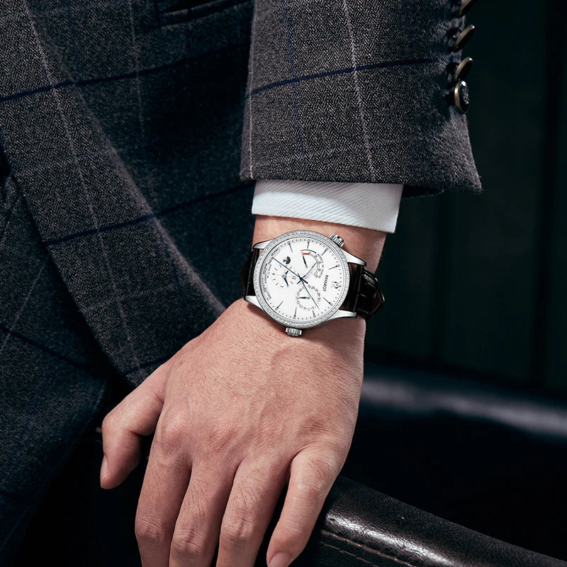 Man wearing white dial multi-function automatic watch with navy blue suit jacket