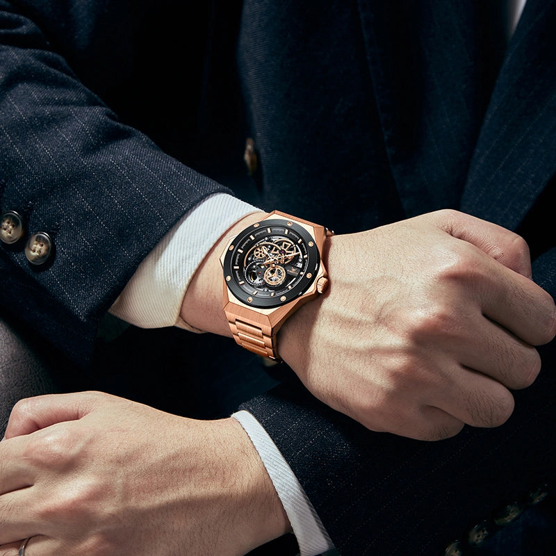 Close-up shot of rose gold mechanical watch worn on wrist with black suit coat