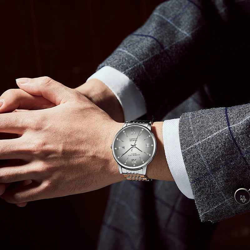 Men's wrist wearing a stainless steel automatic mechanical dress watch paired with a plaid suit jacket