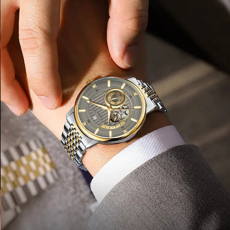 Wrist shot of a man wearing the two-tone skeleton watch paired with a dark suit sleeve