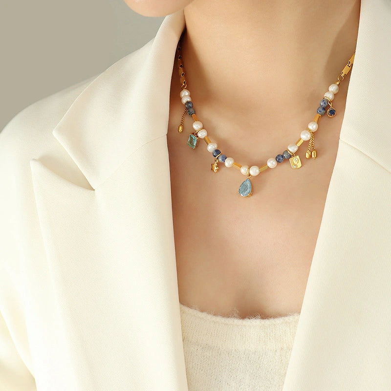 Model wearing the bohemian mixed-media gold necklace with blue stones and pearls