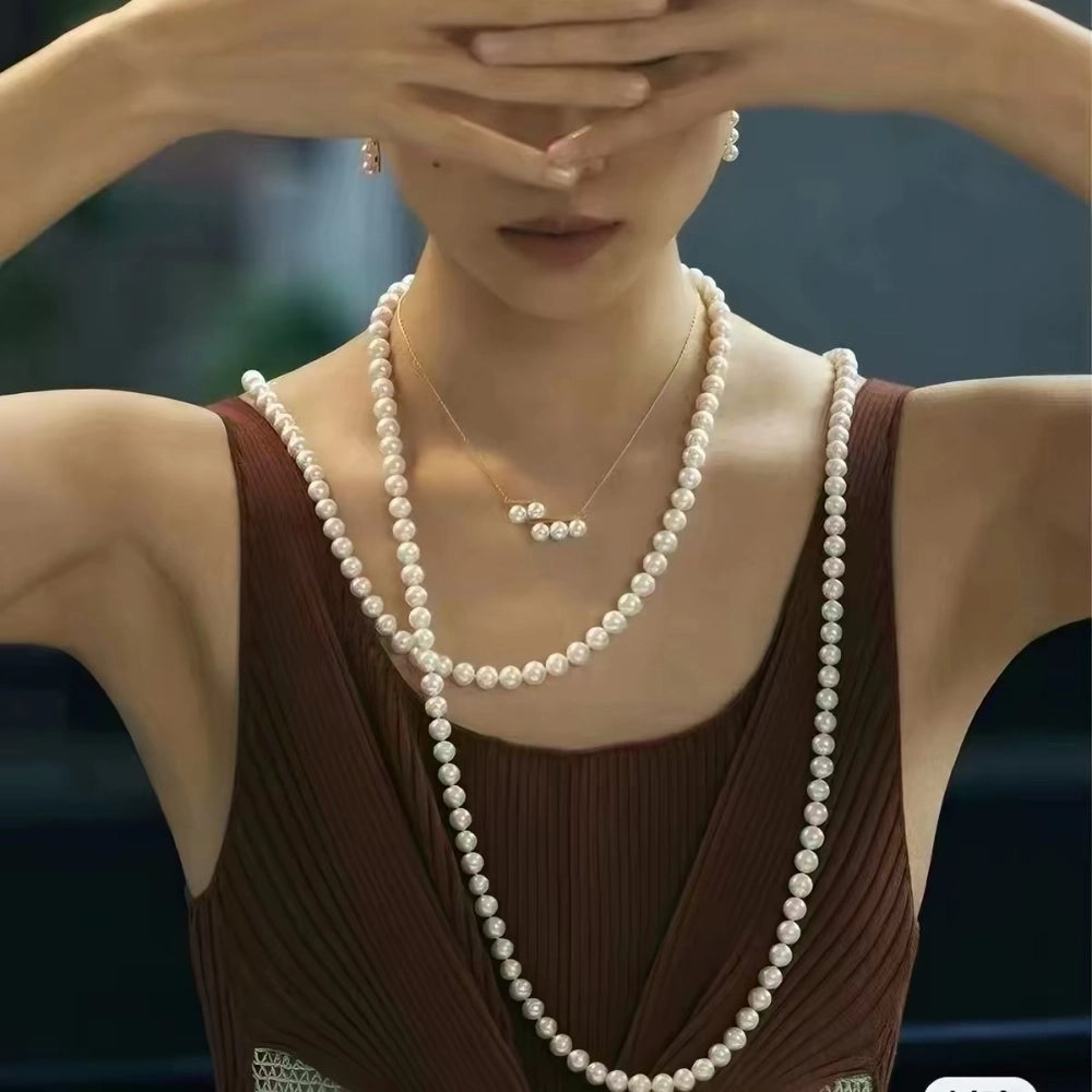 Long freshwater pearl sweater necklace styled with a sweater and blouse, perfect for everyday or formal occasions