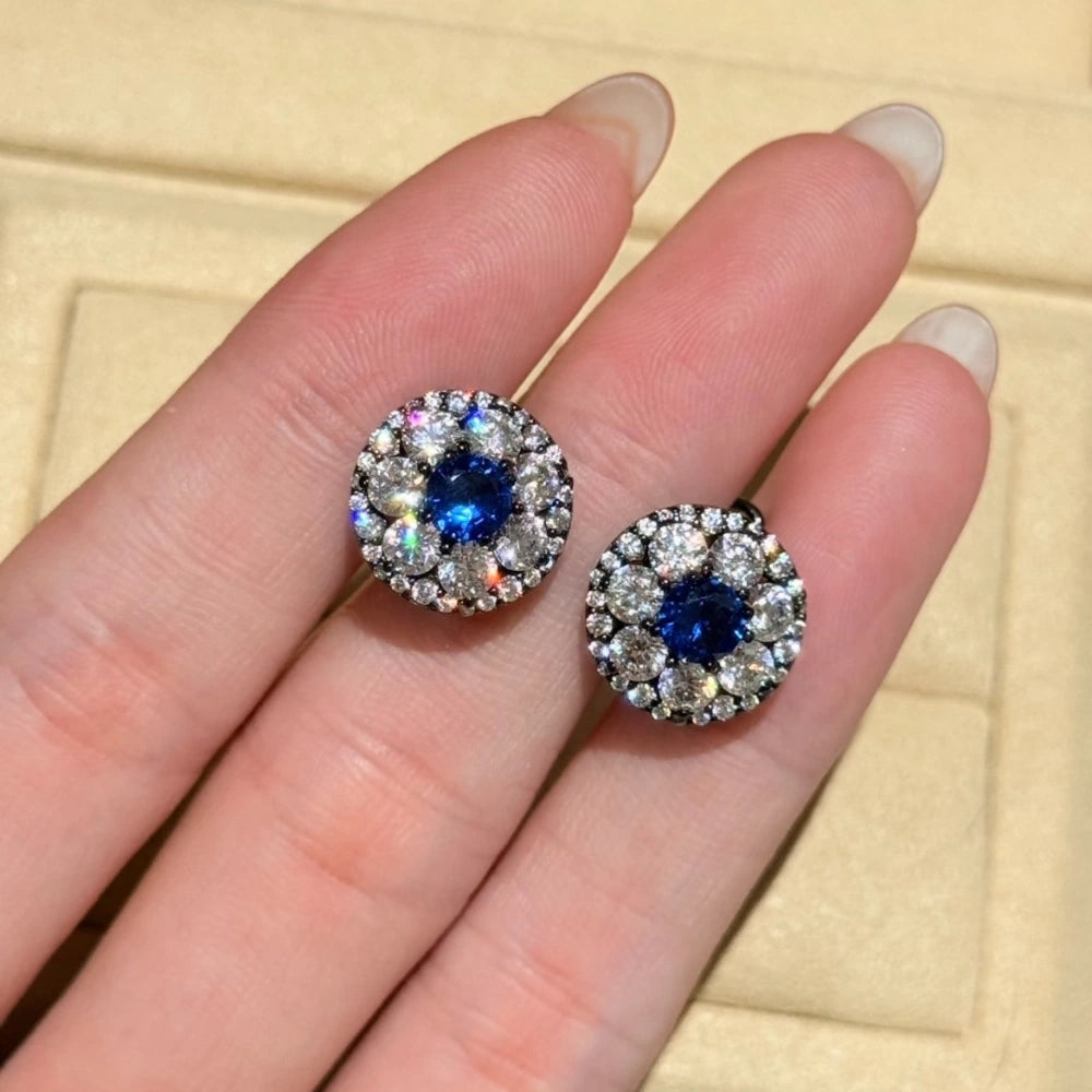 Side view of royal blue halo stud earrings featuring a vintage black gold plated setting and 925 silver posts